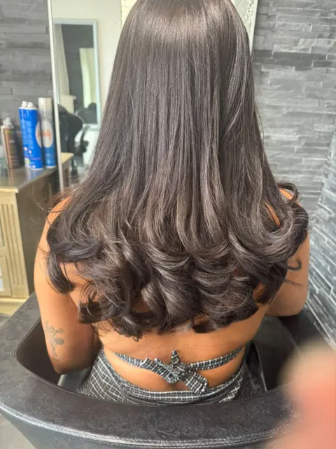 Brushing brillant sur cheveux bruns avec pointes travaillées en boucles