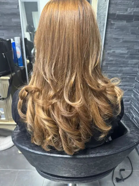 Cheveux longs blond cuivré, brushing ondulé et volumineux
