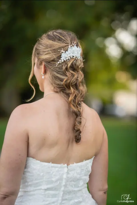 Mariée de dos, tresse ondulée et accessoire floral, photo Cyrille Fragnière